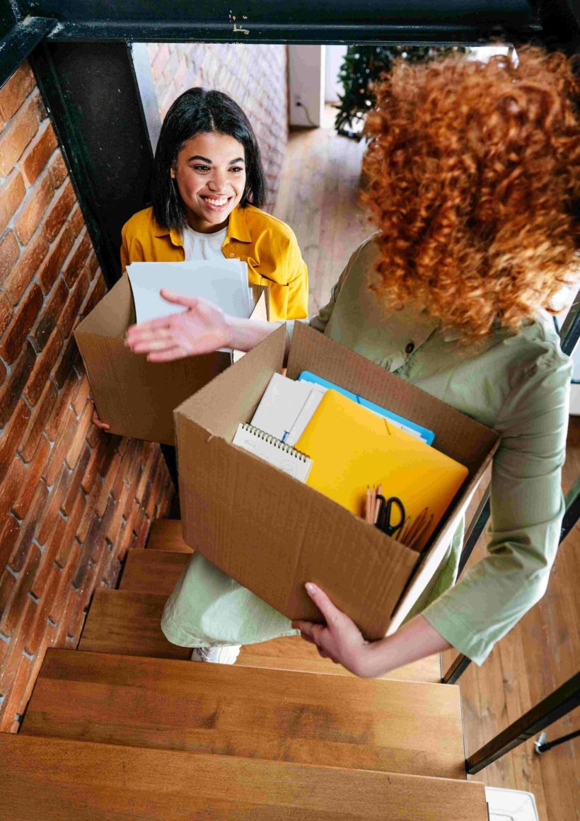 two young happy women moving to new office